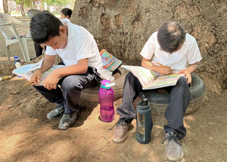 Alumnos tomas clases en el patio de una primaria debido al intenso calor