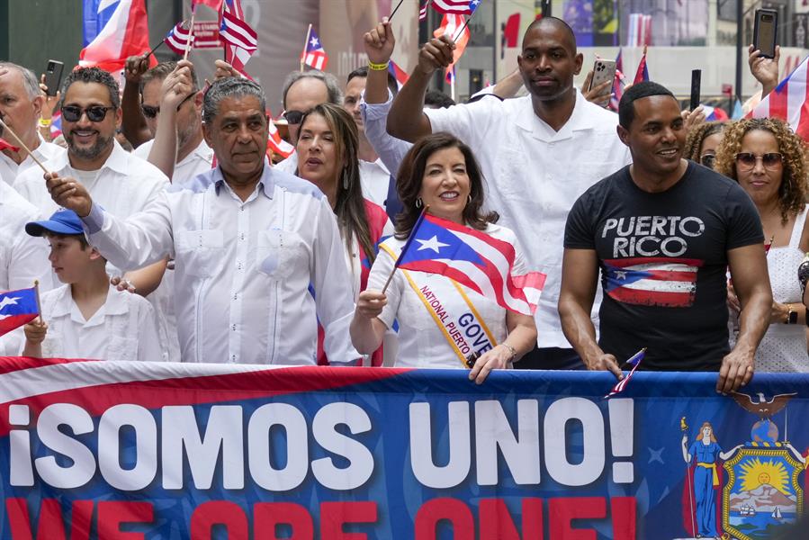 Kathy Hochul (C) marches with Lt. Gov. Anthony Delgado (C-R), and Rep. Ritchie Torres en el desfile puertorrique&ntilde;o