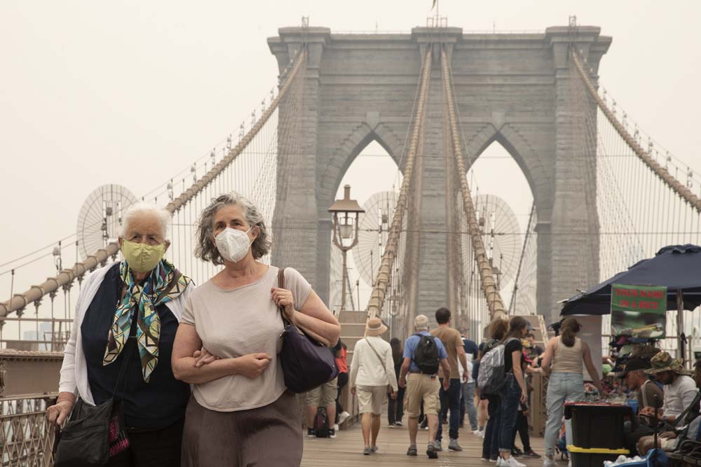 Las personas usan máscaras debido al humo en el aire como resultado de los incendios forestales canadienses que envuelven el área de Nueva York.