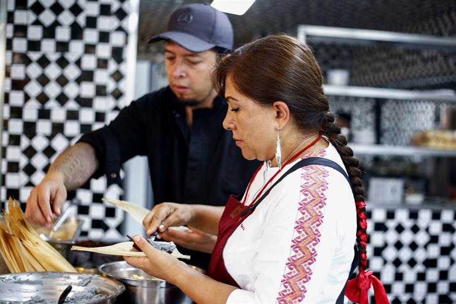 La chef tradicional Olga Cabrera (d) elabora un platillo de mole