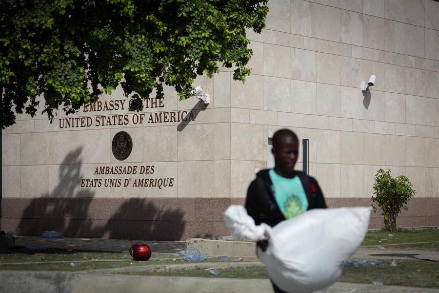 Personas caminan frente a la embajada de Estados Unidos hoy en Puerto Pr&iacute;ncipe (1)