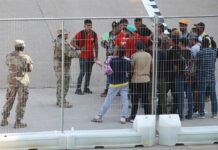 Miembros de la Guardia Nacional de Texas dialogan con un grupo de migrantes (2)