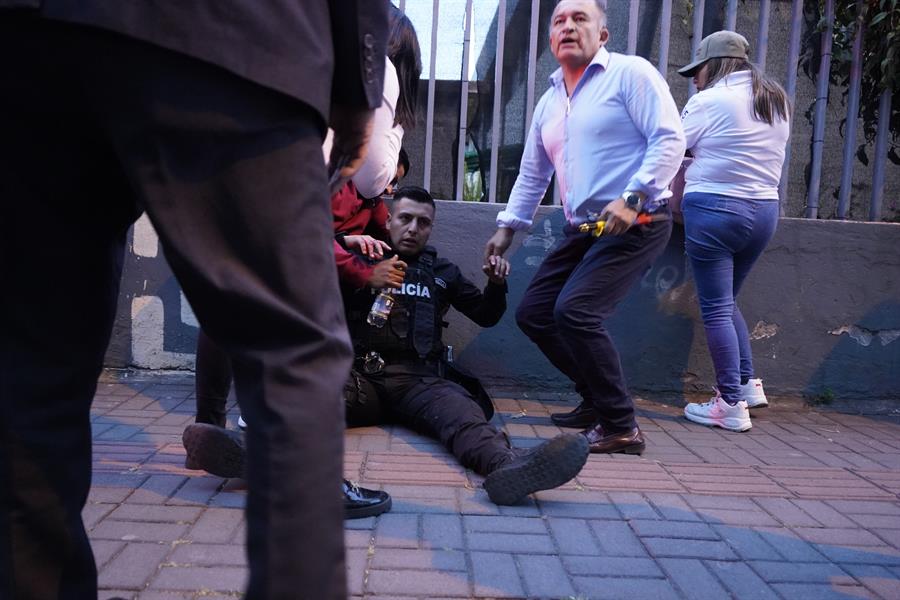 Un polic&iacute;a herido recibe auxilio de parte de los asistentes al mitin con el candidato presidencial Fernando Villavicencio y tras un tiroteo en el cual fue asesinado el aspirante