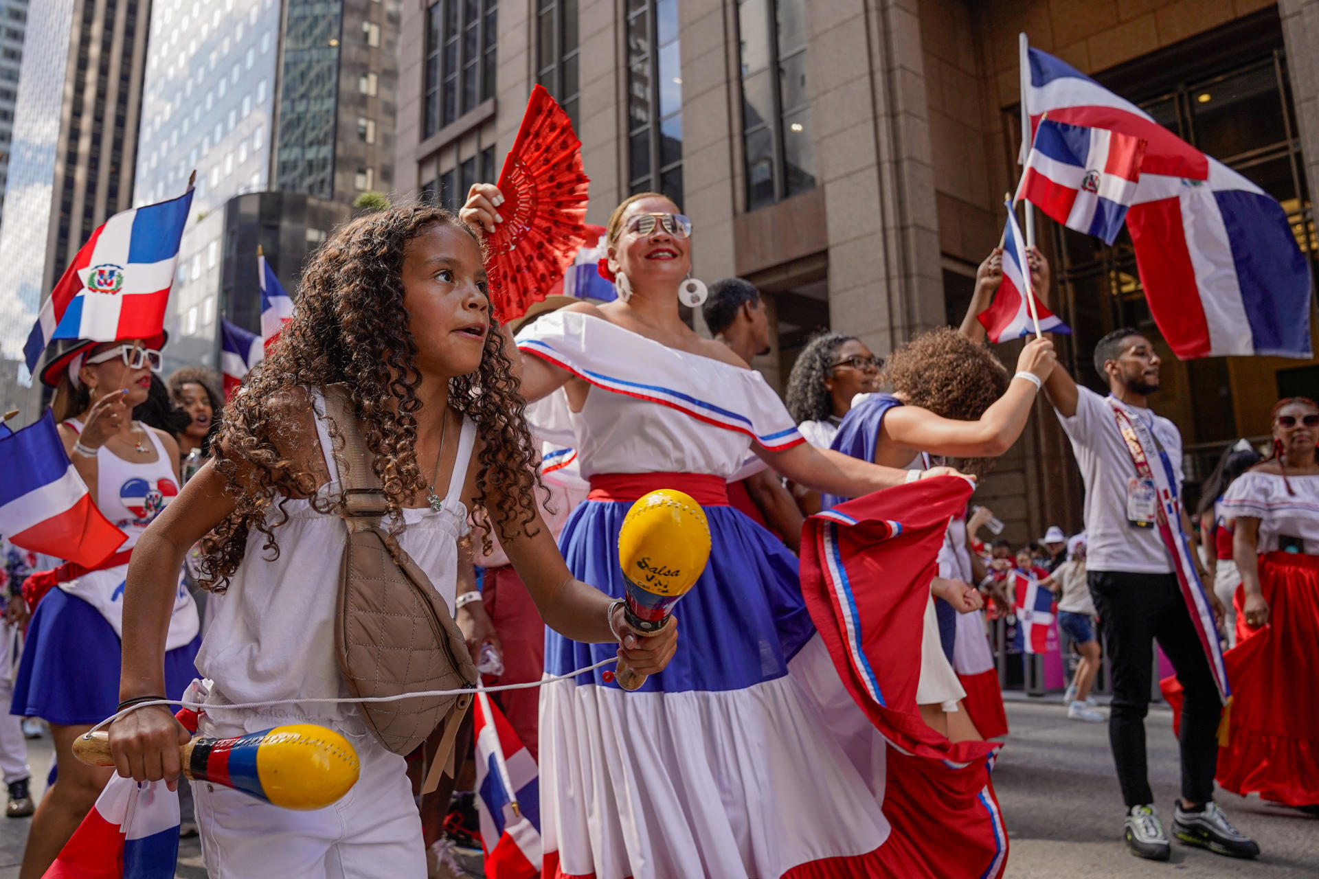 Personas bailan durante el Desfile Dominicano en la Sexta Avenida en Nueva York.