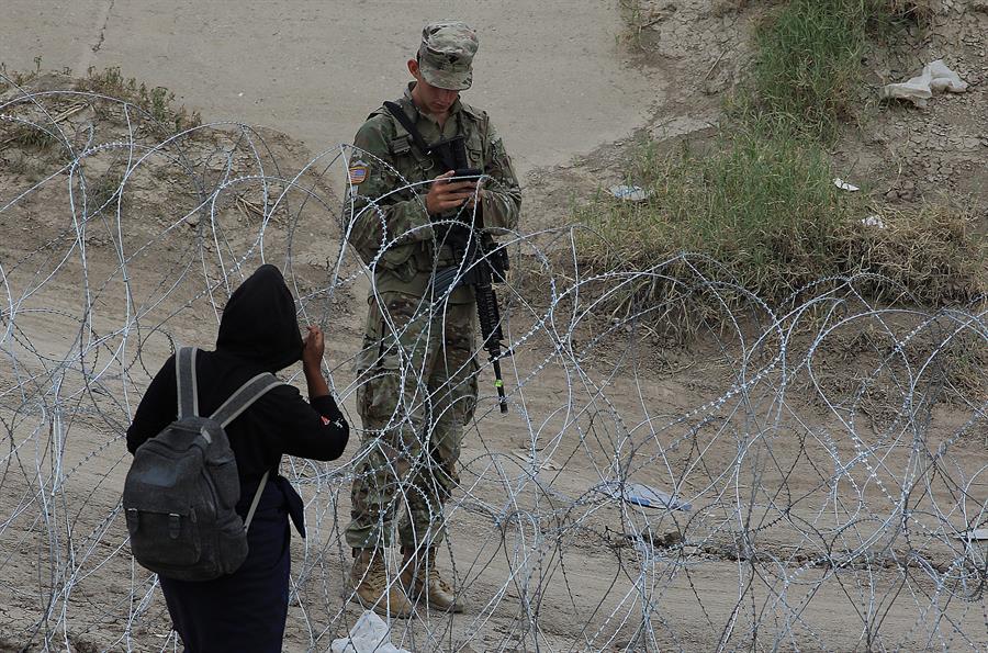 Guardia e inmigante frontera MX EEUU El nivel de violencia y el trato inhumano hacia los migrantes en esta frontera está aumentando, en medio de la desesperación de los indocumentados por librar las barricadas de alambre de navajas colocadas en el río entre la mexicana Ciudad Juárez y El Paso, Texas.