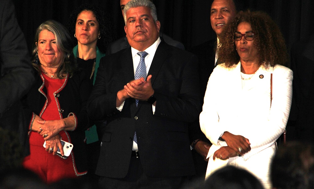 El Fiscal General de Kings County, condado de Brooklyn, durante la entrega de reconocimientos a latinos prominentes en la recepci&oacute;n en la residencia del alcalde Adams, a su derecha la comisionada del Departamento del Envejeciente, Lorraine Cortez y a su otro extremo la asamble&iacute;sta estatal Yudelka Tapia.