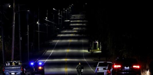 Un policía se dirige al bar Schemengees donde un individuo abrió fuego anoche en la localidad de Lewiston (1)