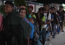 La fila se extiende a lo largo de dos kilómetros de carretera y cuenta con el custodio de policías locales.