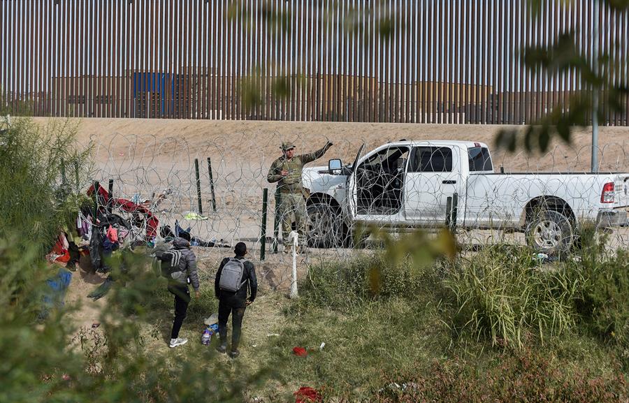 Migrantes hablan con un agente fronterizo de la frontera con Estados Unidos hoy, en Ciudad Juárez, en el estado de Chihuahua, México.