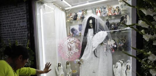Una mujer reza hoy ante la Santa Muerte durante la conmemoración del XXII aniversario de su altar en el popular barrio de Tepito