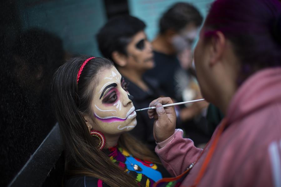 Una turista se maquilla como catrina como parte de las festividades por el D&iacute;a de Muertos
