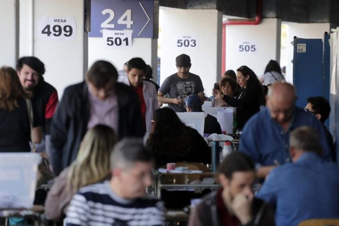Ciudadanos hacen fila para votar en la jornada del plebiscito constitucional
