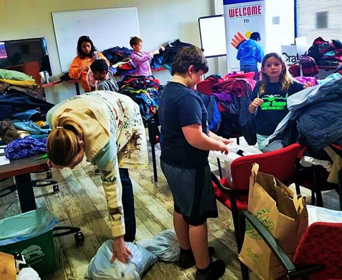 Fotografía cedida por el Centro de Acogida Rocky Mountain donde aparece su directora ejecutiva, Diana Higuera, acompañada de unos niños, mientras recibe las donaciones de los ciudadanos para los inmigrantes, en Denver, Colorado.