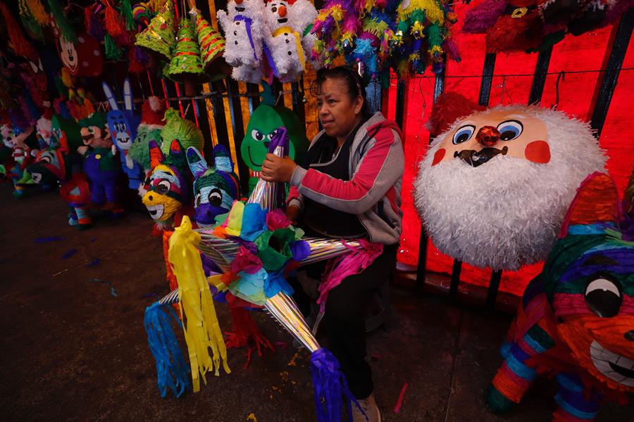 Una vendedora sostiene una piñata en el mercado de Jamaica, el 15 de diciembre de 2023, en Ciudad de México.