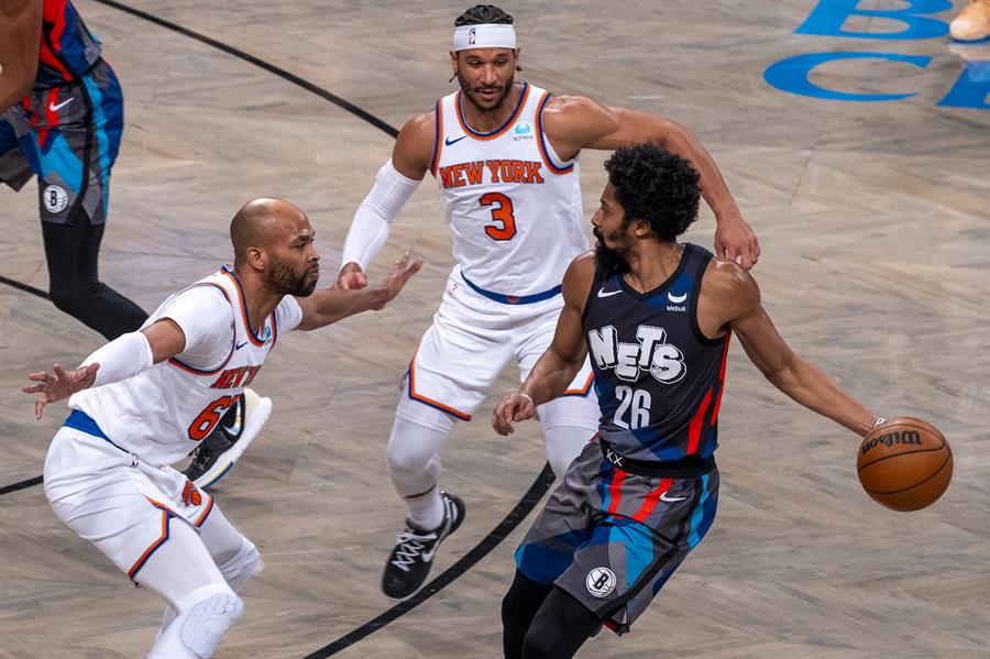Spencer Dinwiddie (d) de los Nets controla el balón ante la marca de Josh Hart (c) y Taj Gibson (i) de los Knicks