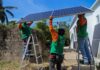 empleados de la empresa colocando páneles solares en el poblado de Cachimbo