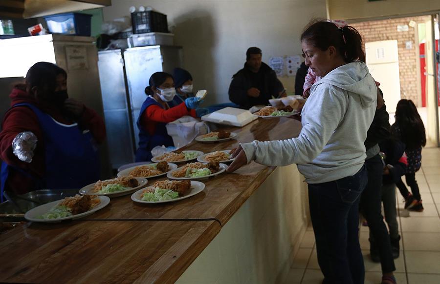 Migrantes reciben comida en el albergue 'La casa del migrante'.