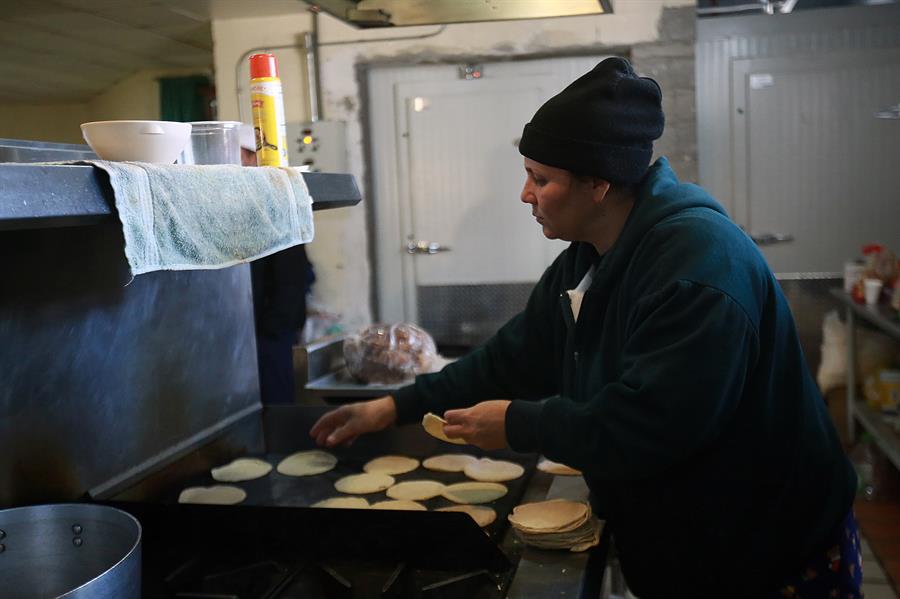 Una migrante prepara alimentos.