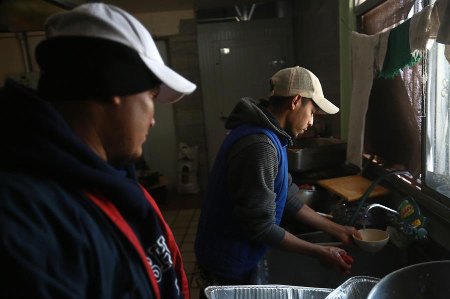 Migrantes trabajan en la cocina del albergue 'La casa del migrante'.