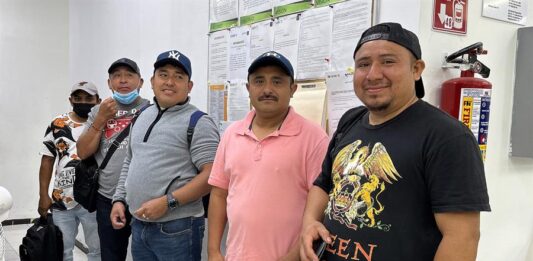 Jornaleros posan antes de viajar a Canadá como parte del Programa de Trabajadores Agrícolas Temporales