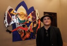 Artista dominicano Chiqui Mendoza mientras posa junto a su obra 'San Miguel de Arcángel' expuesta en la muestra 'Dominican Yorks at the Hispanic Society'.