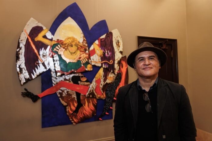 Artista dominicano Chiqui Mendoza mientras posa junto a su obra 'San Miguel de Arcángel' expuesta en la muestra 'Dominican Yorks at the Hispanic Society'.