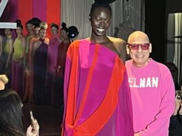 El diseñador venezolano Nabys Vielman camina por la pasarela con una modelo que luce una de sus creaciones