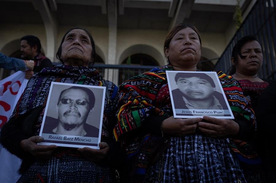 Las viudas de cinco hombres asesinados enseñan sus retratos previo a la audiencia donde un tribunal de Guatemala podría dictar sentencia contra nueve militares acusados de su ejecución el 4 de octubre de 2012.