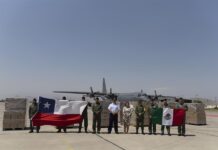La embajadora de México en Chile, Laura Moreno (c-d), posa junto a oficiales que sostienen las banderas de Chile (i) y México