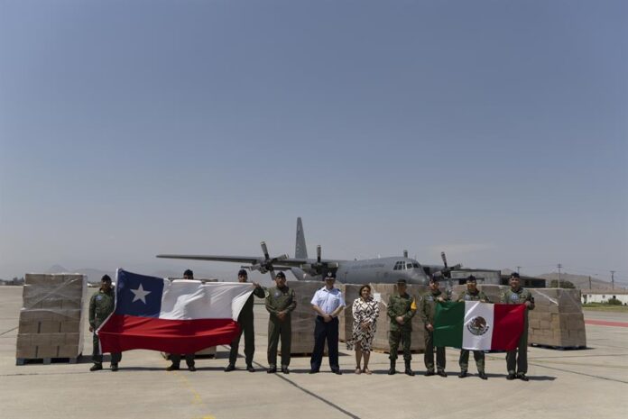 La embajadora de México en Chile, Laura Moreno (c-d), posa junto a oficiales que sostienen las banderas de Chile (i) y México La embajadora de México en Chile, Laura Moreno (c-d), posa junto a oficiales que sostienen las banderas de Chile (i) y México