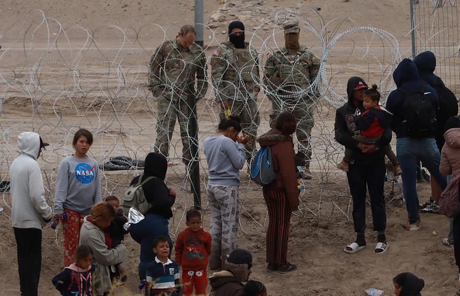Migrantes intentan cruzar la cerca de alambres en la frontera que divide a México de los Estados Unidos (1)