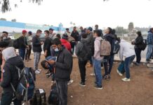 Un grupo de migrantes liberados por la Patrulla Fronteriza esperan un autobús (2)