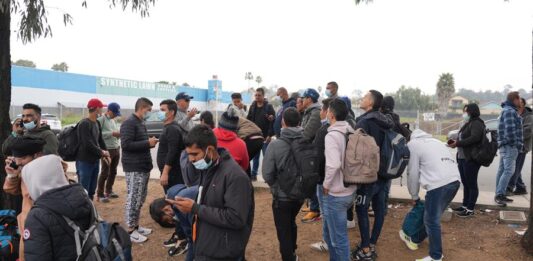 Un grupo de migrantes liberados por la Patrulla Fronteriza esperan un autobús (2)