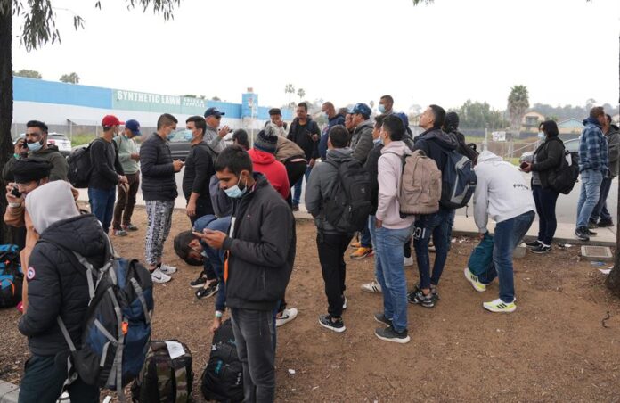 Un grupo de migrantes liberados por la Patrulla Fronteriza esperan un autobús (2) Un grupo de migrantes liberados por la Patrulla Fronteriza esperan un autobús (2)