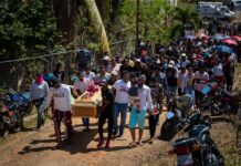 Familiares y simpatizantes participan en la ceremonia de entierro de una de las victimas mortales del derrumbe en la mina 'Bulla Loca', este jueves, en La Paragua, Venezuela.