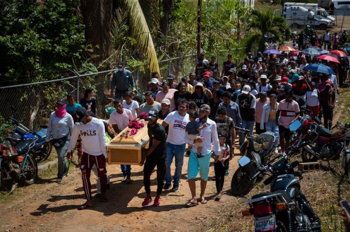 Familiares y simpatizantes participan en la ceremonia de entierro de una de las victimas mortales del derrumbe en la mina 'Bulla Loca', este jueves, en La Paragua, Venezuela.