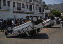Personas bloquean unas calles este jueves, durante una protesta por el secuestro y asesinato de la menor Camila Gómez, en el municipio de Taxco, en el estado de Guerrero, México.