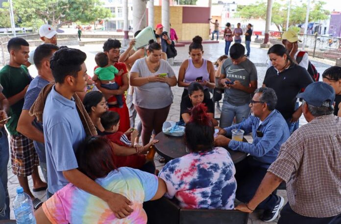 El coordinador del CDH, Luis Rey García Villagrán (d), habla durante una reunión con migrantes ecuatorianos inmigrantes