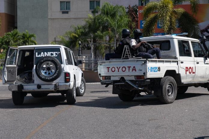 Empleados municipales escoltados por la policía trasladan varios cuerpos calcinados a una fosa común en un cementerio, este viernes en Puerto Príncipe Haiti