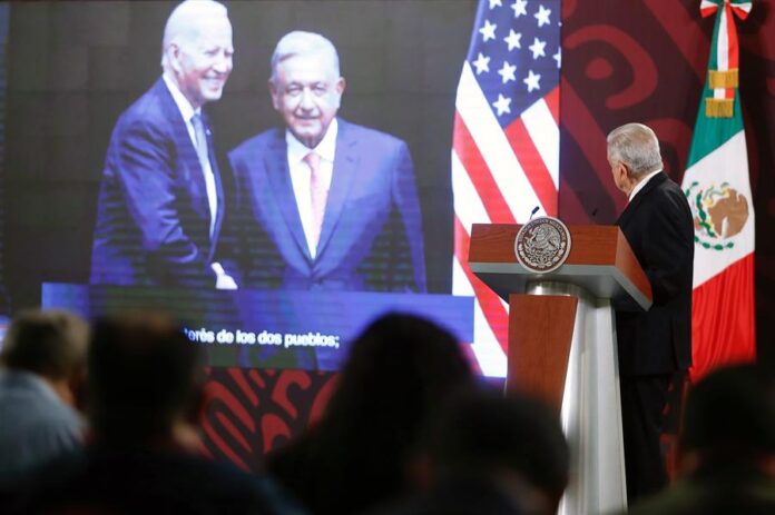 El presidente de México, Andrés Manuel López Obrador, observa una imagen proyectada de sí mismo junto al presidente estadounidense, Joe Biden.