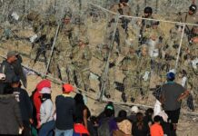 Personal de la Guardia Nacional estadounidense refuerzan una cerca de navajas y púas (1)