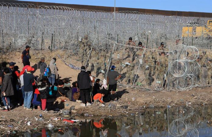 Personal de la Guardia Nacional estadounidense refuerzan una cerca de navajas y púas