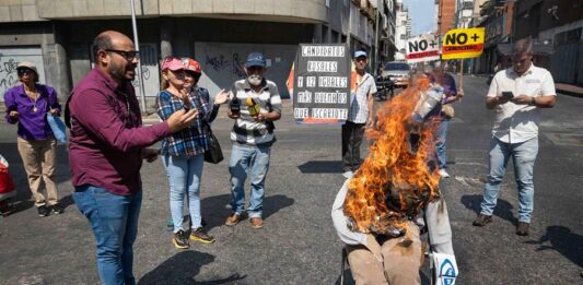 Personas participan en la tradicional Quema de Judas con un muñeco con la imagen del presidente de Venezuela, Nicolás Maduro