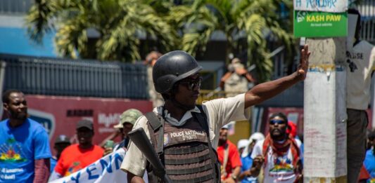 Policías vigilan a manifestantes que se congregan frente a la embajada canadiense