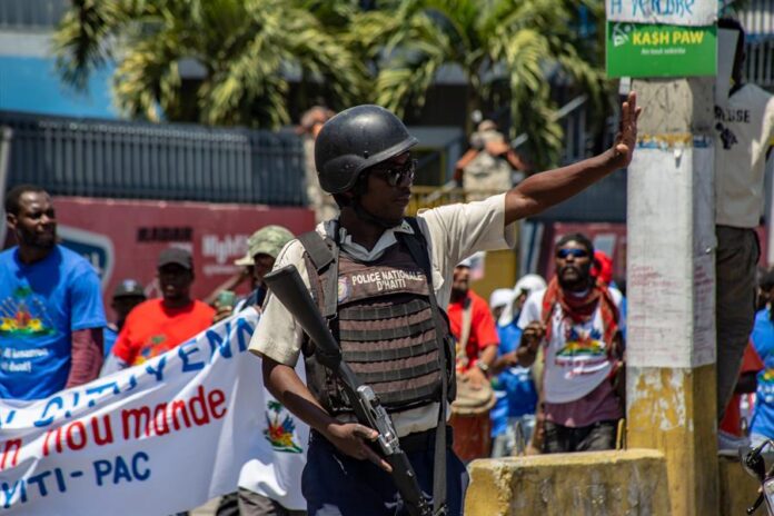 Policías vigilan a manifestantes que se congregan frente a la embajada canadiense