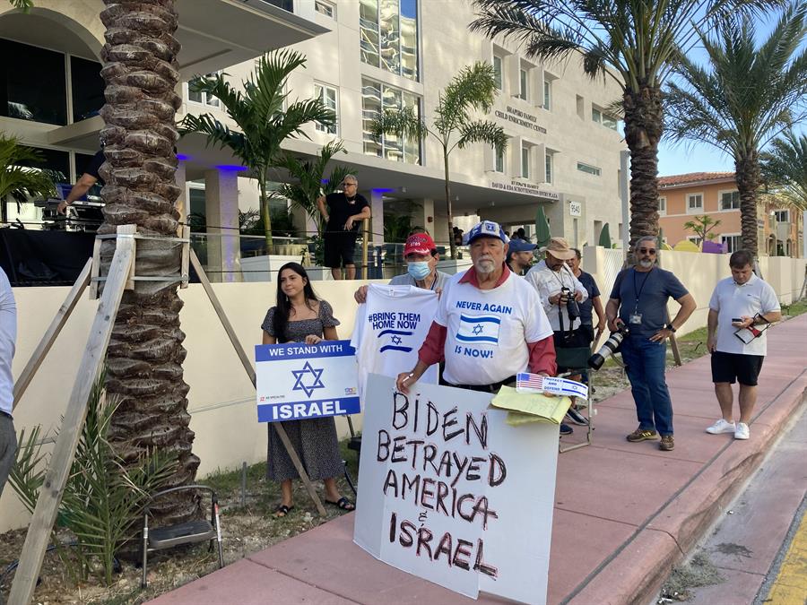 Varias personas vestidas con camisetas que llevan la bandera de Israel y carteles se manifiestan en los alrededores de la sinagoga The Shul Jewish