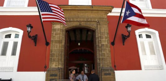 edificio gubernamental donde ondean las banderas estadounidense y puertorriqueña en San Juan