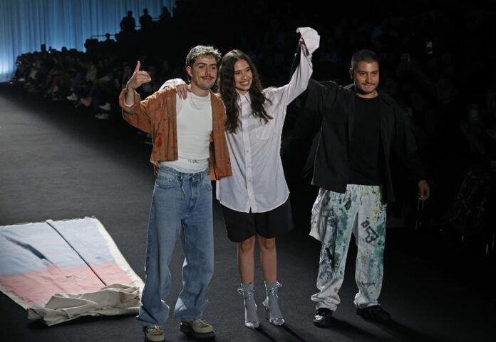 El baterista de la banda colombiana Morat, Martín Vargas (i), saluda luego de presentar prendas de la marca 'General' en una pasarela del Bogotá Fashion Week,