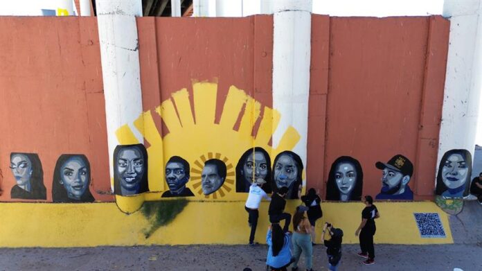 La artista mexicoestadounidense Lizbeth de la Cruz Santana pinta un rostro de migrantes deportados bajo el puente Internacional Paso del Norte (2)