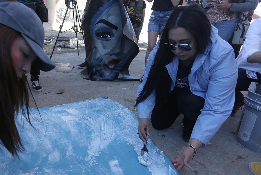 La artista mexicoestadounidense Lizbeth de la Cruz Santana pinta un rostro de migrantes deportados bajo el puente Internacional Paso del Norte (3)